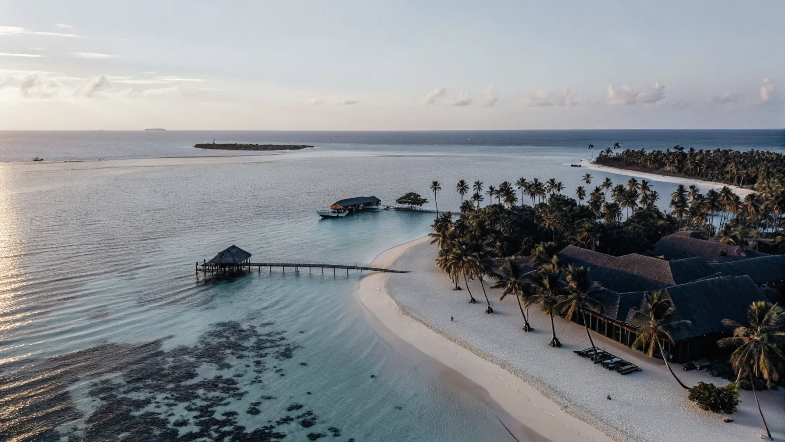 Tirkīzzila okeāna ūdens ar baltām smiltīm un palmām eksotiskā pludmalē