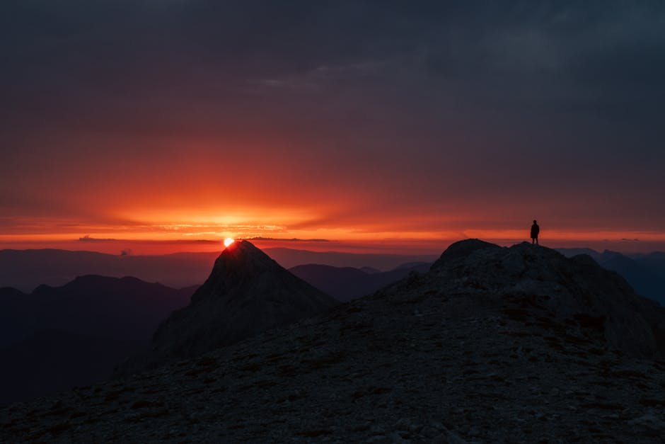 Vīrietis pie sporta auto uz ledus trases Somijā ar ziemeļblāzmu debesīs