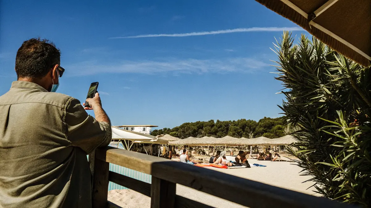 Ceļotājs ar mugursomu pie lidostas izlidošanas tabulas plāno maršrutu