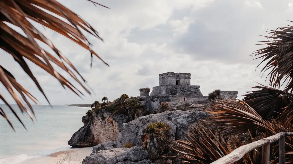 Tuluma piramīda uz klints ar tirkīzzilu karibiskās jūras fonu