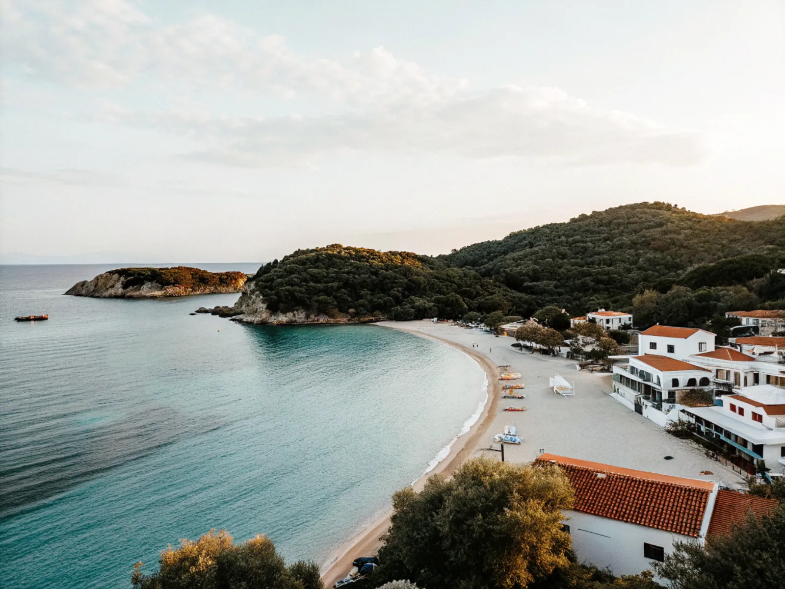 Vidusjūras pludmale ar tirkīzzilu ūdeni un baltu smilšu joslu — vasaras ceļojuma galamērķis