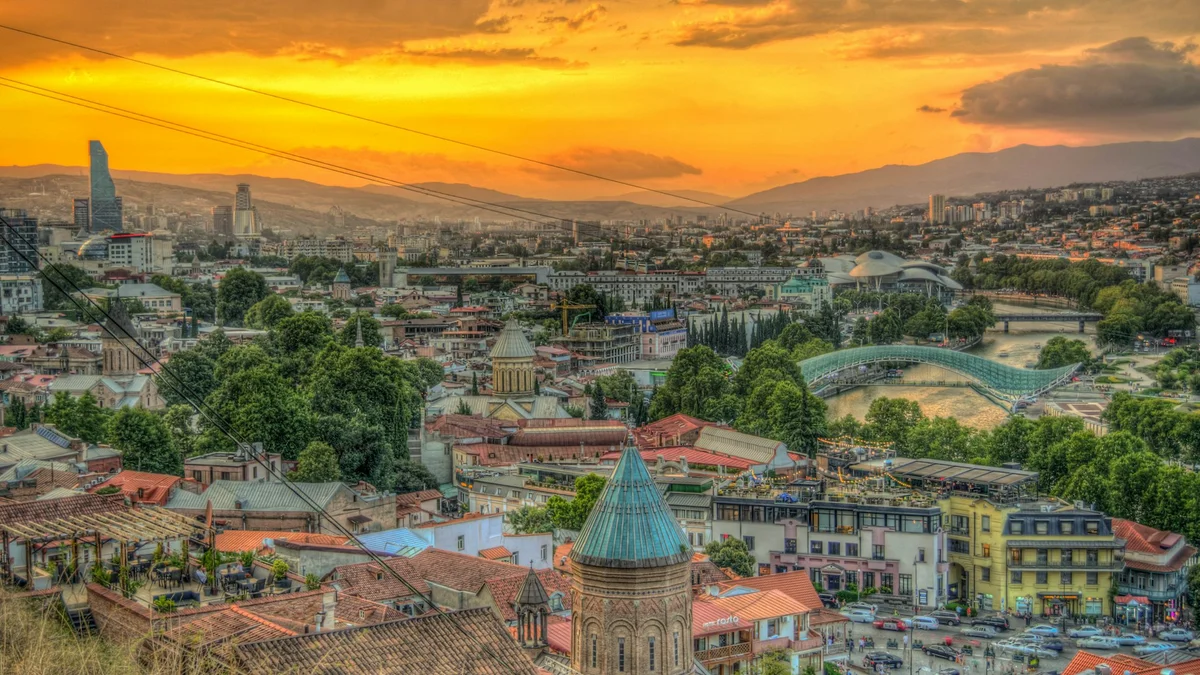 Batumi pludmale ar modernajām pilsētas ēkām fonā un Melno jūru priekšplānā